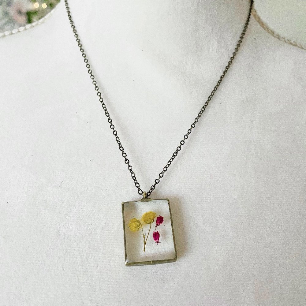 Yellow and pink floral botanical resin necklace in dark silver bezel